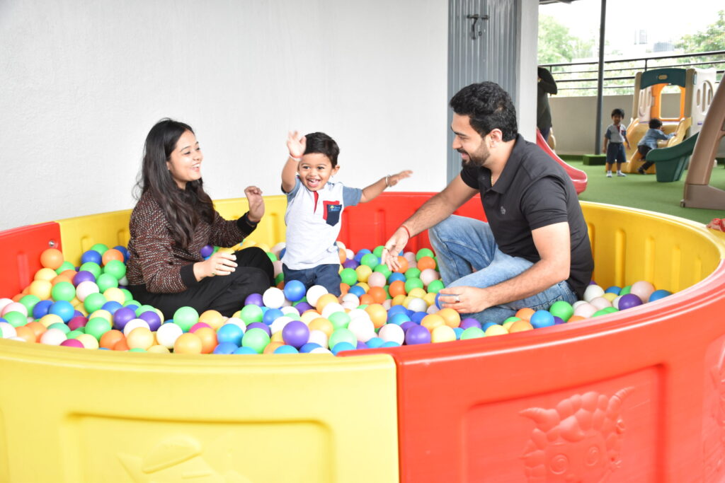 kid playing with parents in bucket of colourful balls at cherubs