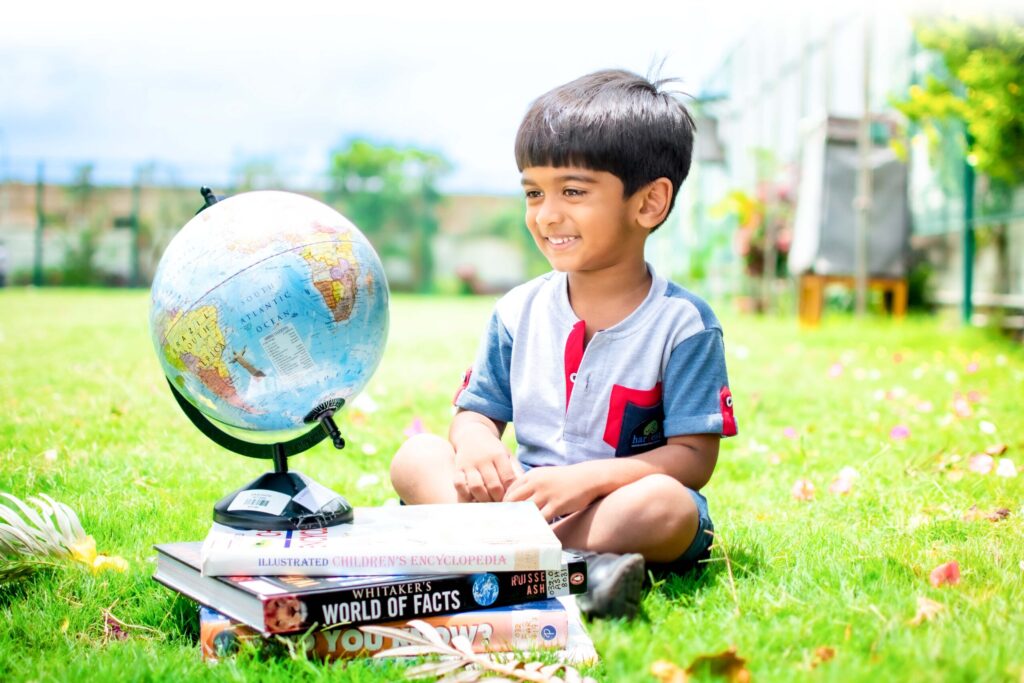 kid playing with educational globe