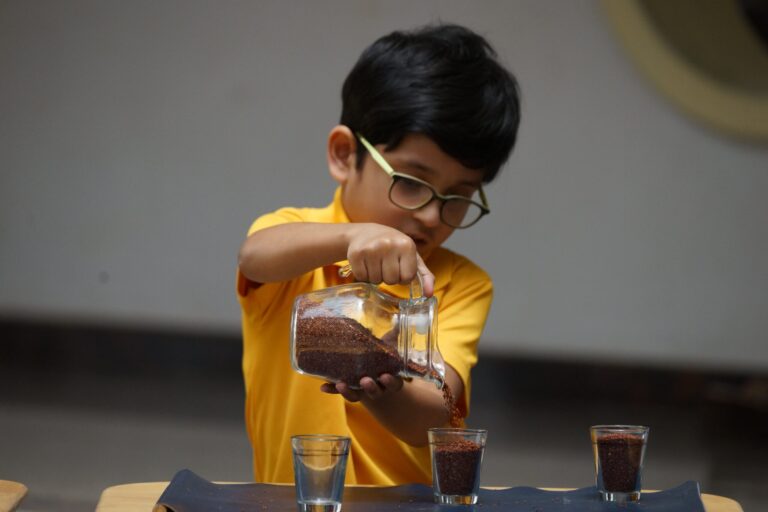 kid learning by play with measuring cup