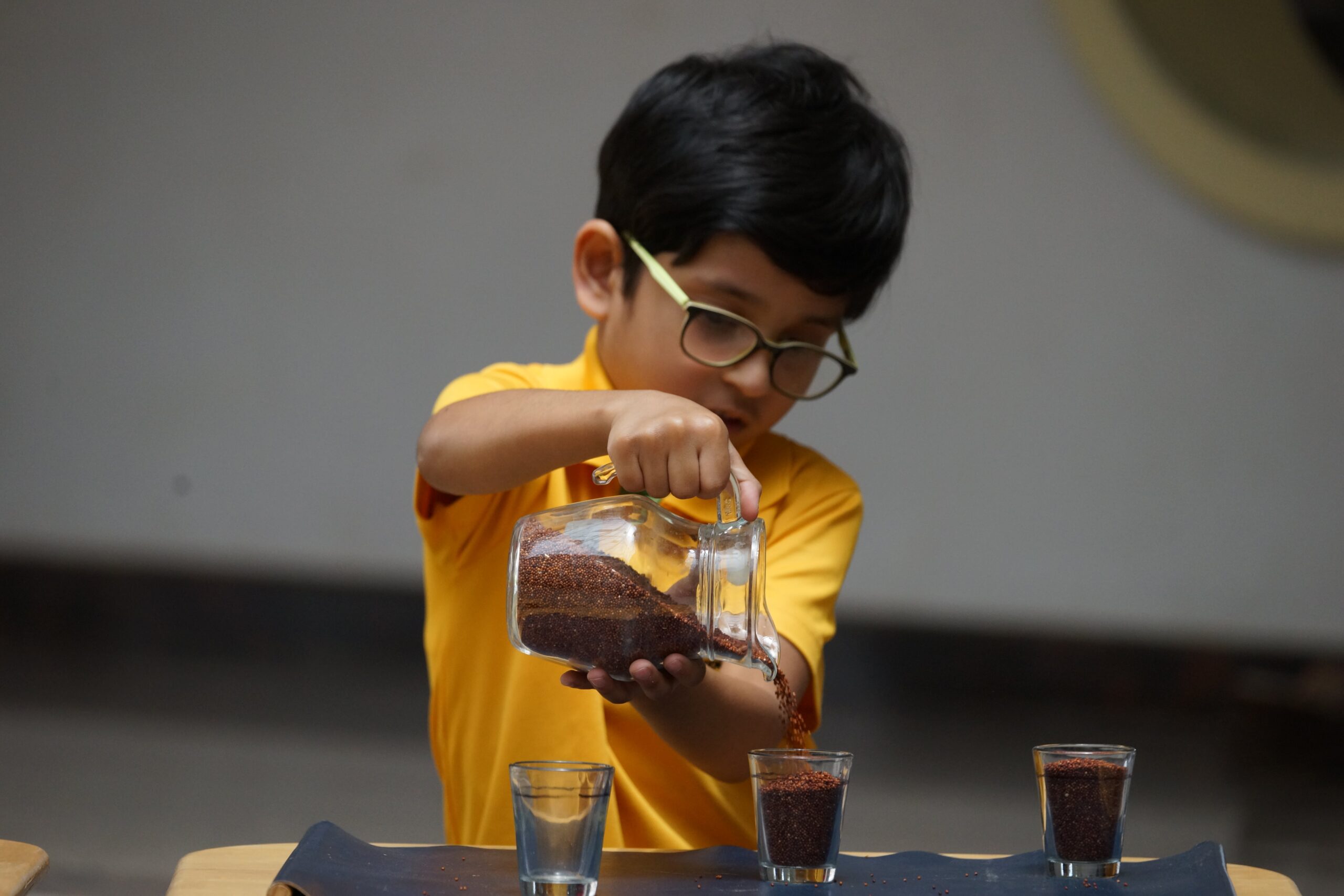 kid learning by play with measuring cup