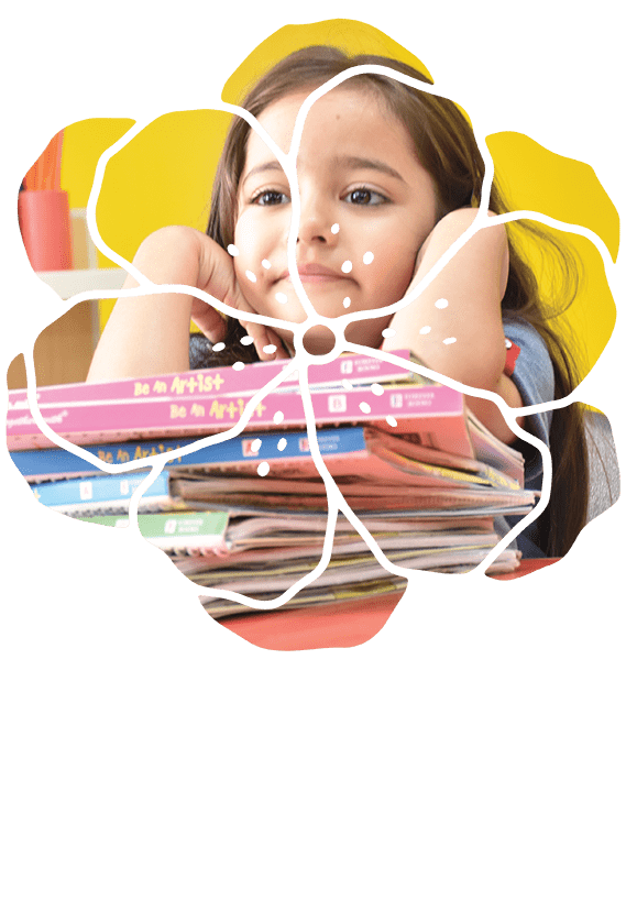 Smiling young girl resting on a stack of colorful books